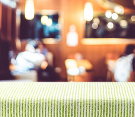 Aufkleber - Table with green pattern tablecloth with blur restaurant backgro