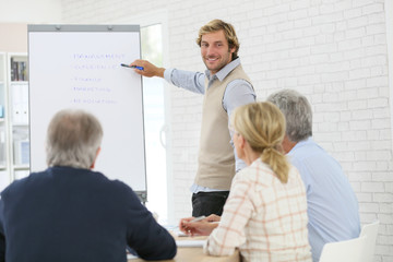 Business instructor leading meeting with senior training group