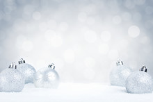 Silver Christmas Baubles On Snow With A Silver Background