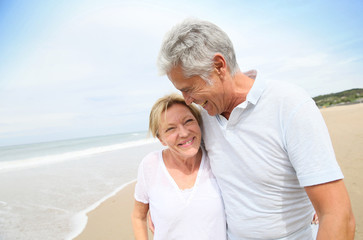 Wall Mural - Married senior couple having fun walking in the beach