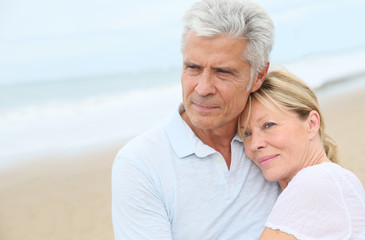 Wall Mural - In love senior couple embracing at the beach