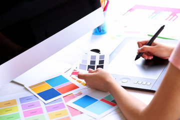 Artist drawing on graphic tablet in office