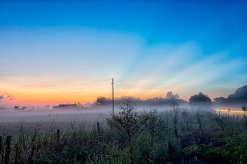 Wall Mural - early sunrise over foggy farm landscape in rock hill south carol