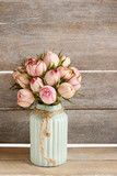 Fototapeta Kwiaty - Bouquet of pink roses in turquoise ceramic vase