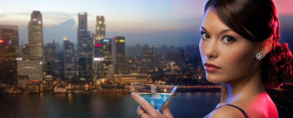 Poster - woman holding cocktail over singapore night city