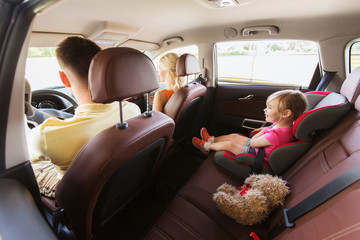 Poster - happy parents with little child driving in car