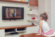 © Myst - cute little girl having remote control and watching tv at home