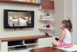 © Myst - cute little girl having remote control and watching tv