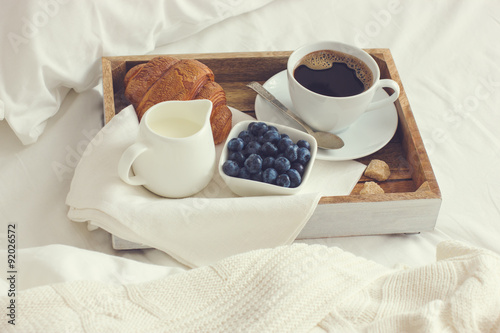 Láminas Taza de café, croissant y arándanos frescos en bandeja de madera, bre