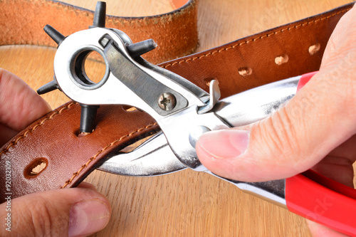 Fotografía Punching holes on leather belt
