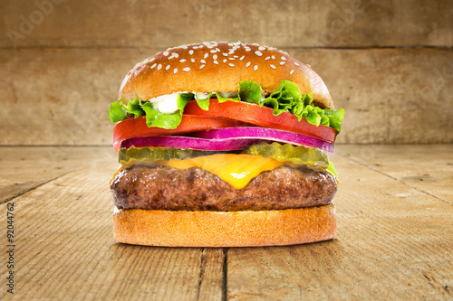 Fotografie, Obraz Single solo burger hamburger cheeseburger on table wooden surface delicious perf