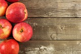 Freshly harvested apples, side border on rustic aged wood background