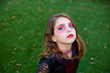 Halloween makeup kid girl blue eyes in outdoor lawn