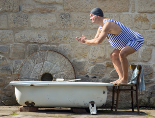 man in retro swimsuit jumps to the outdoor bathtub