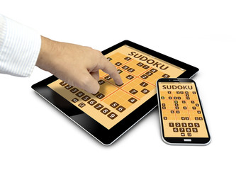 Canvas Print - group of touchscreen devices with sudoku game and a finger touch