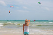 © stock.film - girl is standing back on the beach and looks at sea with parasailing