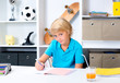 © Firma V - blond boy doing homework