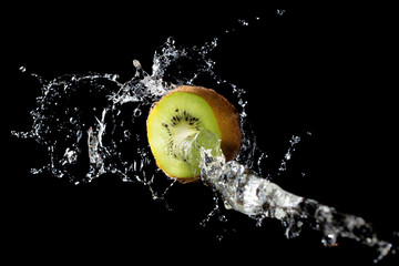 Wall Mural - Kiwi slice in water splash on black background