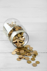 Poster - Coins in money jar on wooden background