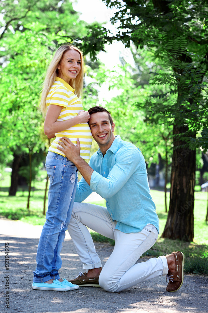 Young pregnant woman with husband in park