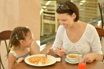 Wall Mural - Little girl with mother eats