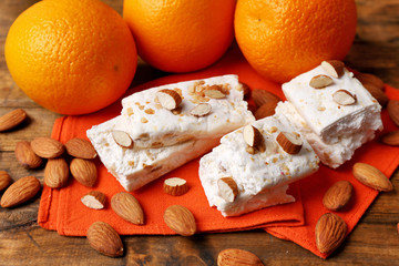 Poster - Sweet nougat with almonds and oranges on table close up