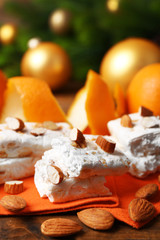 Wall Mural - Sweet nougat with oranges and Christmas decoration on table close up