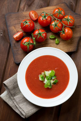 Wall Mural - Gazpacho soup and fresh tomatoes on a rustic wooden background