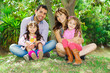 © Fotos 593 - Beautiful hispanic family of four sitting outside on grass