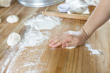 Female baker kneading dough in a bakery