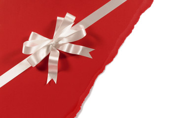 Wall Mural - Gift ribbon and bow in white satin on untidy torn red paper background