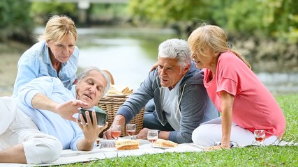 Canvas Print - Group of senior people enjoying picnic on sunny day