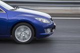 Fototapeta Perspektywa 3d - blue car fast rigde on the road closeup