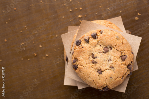 Fotografie, Obraz Stacked chocolate chip cookies on brown wooden table