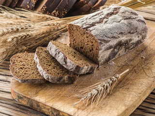 Wall Mural - Sliced black bread on the wooden plank.