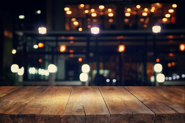 Wall Mural - image of wooden table in front of abstract blurred background of resturant lights
