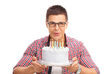 Wall Mural - Joyful man blowing candles on a birthday cake