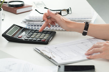 Close up of female accountant or banker making calculations