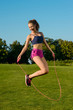 Girl funny jumping on jump rope with a smile.
