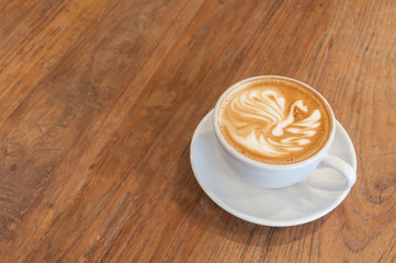 Wall Mural - Hot cafe latte with latte art on wooden table