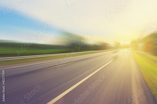 Plakat Pusta asfaltowa droga w ruch plamie i światło słoneczne z rocznika brzmieniem