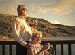 Couple of elderly people drinking a glass of wine at sunset