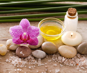 wooden background -orchid , stones, candle, oil and pile of salt

