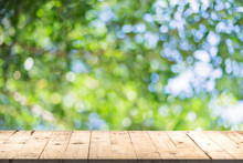 Wood Table Perspective And Green Leaf Bokeh Blurred For Natural