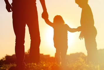 Wall Mural - Silhouette of father with two kids walking at sunset