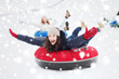 © Syda Productions - group of happy friends sliding down on snow tubes