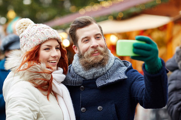 Canvas Print - couple taking selfie with smartphone in old town