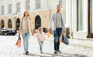 Wall Mural - happy family with child and shopping bags in city
