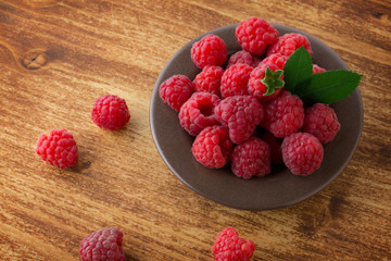 Wall Mural - raspberries in bowl on wood  table