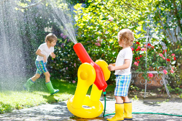 Wall Mural - Two little kids playing with garden hose in summer